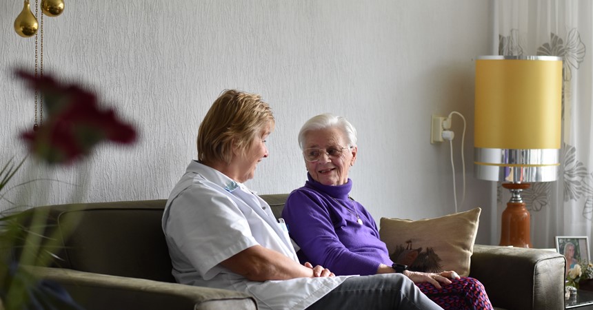 De Wijkverpleegkundige Maakt Een Praatje Met Haar Cliënt